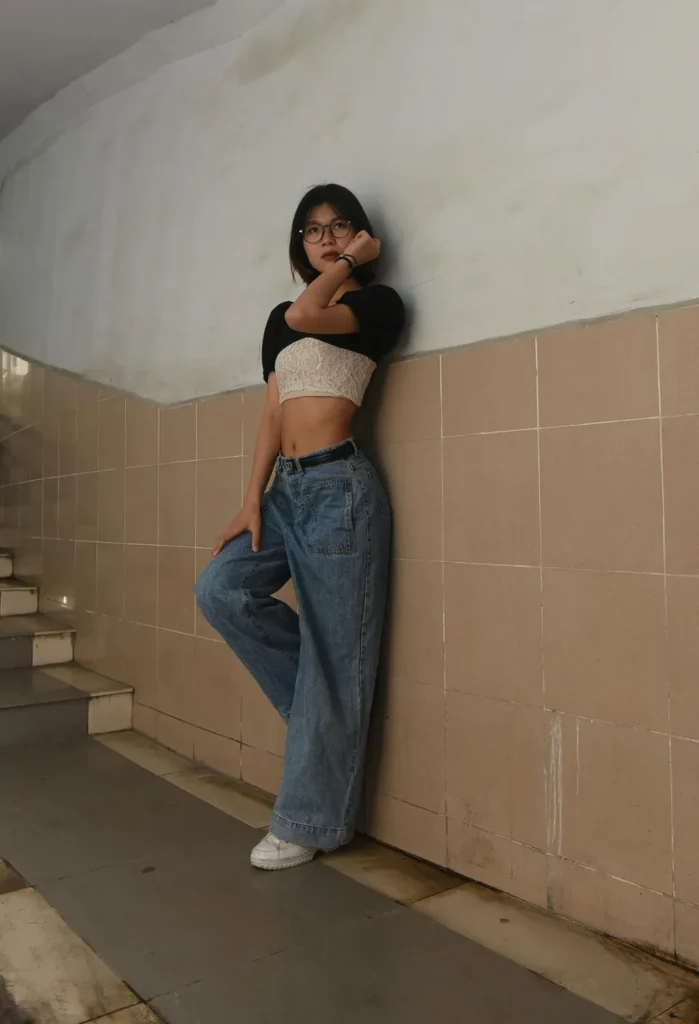 pairing a bralette with a sleeve shrug over baggy jeans